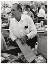 George W. Jenkins bagging and speaking with customer