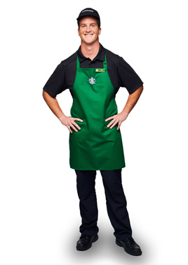 Barista with green apron and black shirt and hat